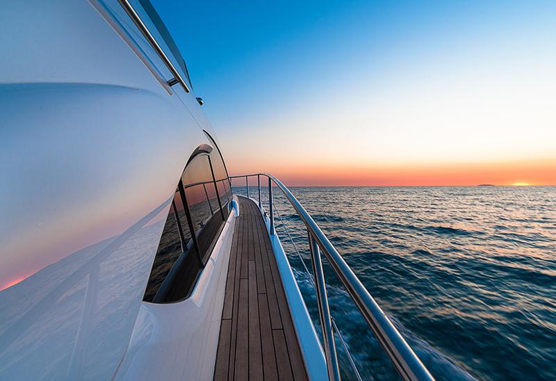 Yacht cruising in water during sunset