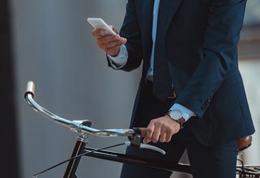 business man on a bike checking his phone